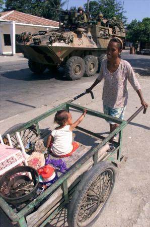 An East Timorese Mother Wheels her Child and Belongings in Dili